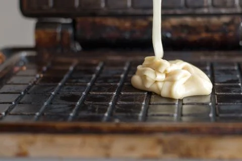 White batter into the waffle iron baking waffles Stock Photos