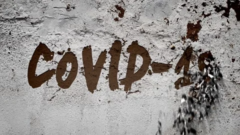 On the white, battered concrete wall appears the inscription:" COVID-19 " Stock Footage 128133119