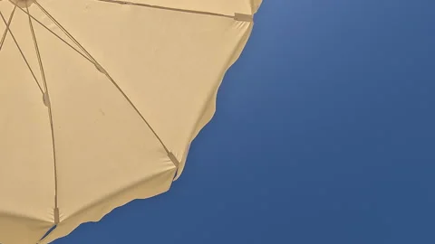 White beach umbrella. Relaxing context. Summer holidays by the sea Vidéo 267527150