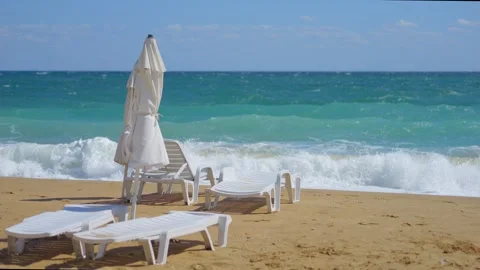 White beach umbrellas flapping in the wind against the sea in 4k slow motio.. Stock Footage 284309668