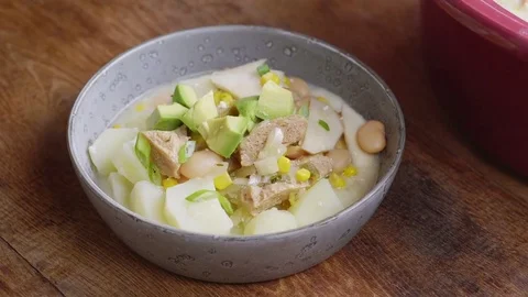 White bean chili being garnished with spring onion greens Stock Footage 84843151