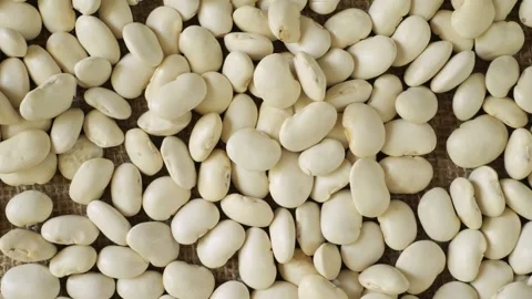 White beans slowly moving on a burlap surface Stock Footage 337441219