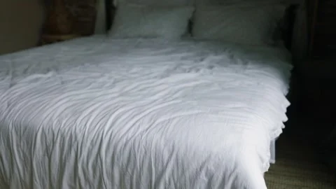 White bed with crumpled sheets and pillows in luxury hotel room Stock Footage 320824713