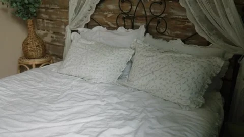 White bed with crumpled sheets and pillows in luxury hotel room Stock Footage 320824723