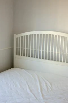 White bed in an empty bright room Stock Photos