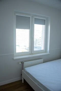 White bed in an empty bright room Stock Photos