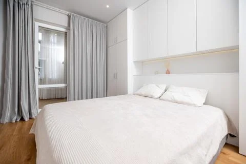 A white bed with a white comforter and pillows Stock Photos