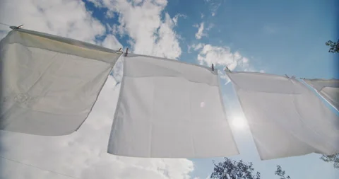 White bedding drying on a rope in the sun Stock Footage 207855940