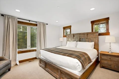 White bedroom interior with master bed and exit to back patio. Stock Photos