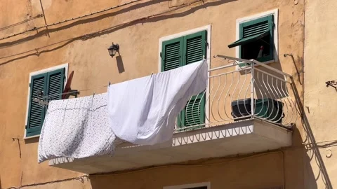 White bedsheets drying on balcony of an old building in Italian town Stockbeeldmateriaal 341485189