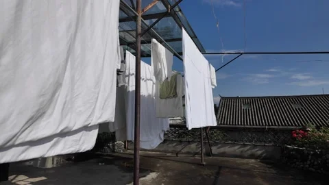 White Bedsheets Drying in the Mountain Breeze on a Hostel Rooftop in Dali, .. Stock Footage 340516829