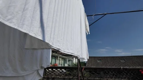 White Bedsheets Drying in the Mountain Breeze on a Hostel Rooftop in Dali, .. Stock Footage 340516864