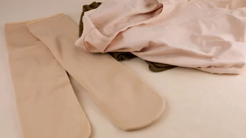 White, beige and gray knitted women's panties fall on nylon socks and tights.  Stock Footage 297447493