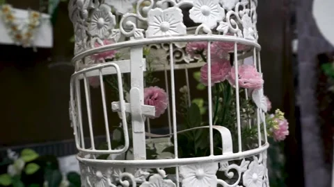 A white birdcage with flowers in it Stock-Footage 235924990