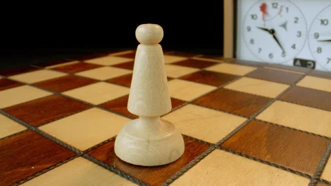 White bishop on a rotating chess board Video stock 112049757