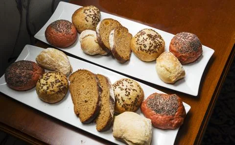 White, black, gray bread of different varieties on a white plate on the table Stock Photos