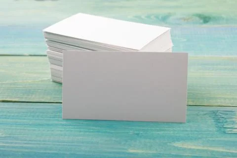 White blank business visit card, gift, ticket, pass on blue wooden background Stock Photos