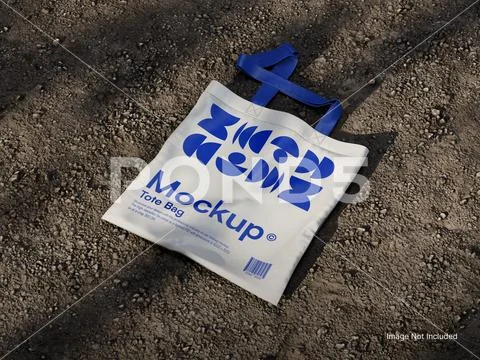 White Blank Canvas Tote Bag Mockup on a Soil Ground PSD Template