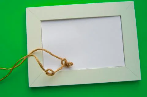 White blank frame with space for text lies on a green background, decorated w Stock Photos