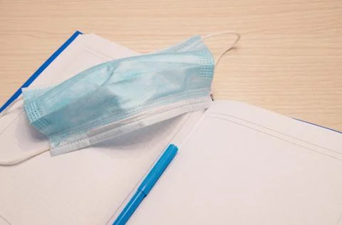 White blank notebook in a cage for recording lies on a wooden background with Stock Photos