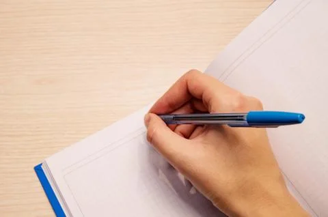 A white blank notebook in a cage for writing lies on a wooden background, the Stock Photos
