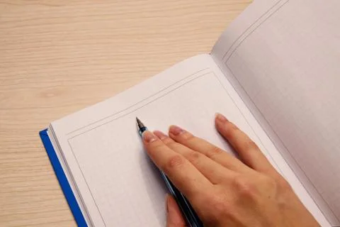 A white blank notebook in a cage for writing lies on a wooden background, the Stock Photos