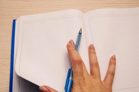 A white blank notebook in a cage for writing lies on a wooden background, the Stock Photos