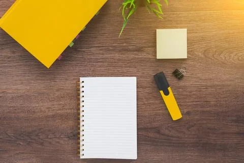 White blank notebook for notes, a textbook and marker on a brown wooden des.. Stock Photos