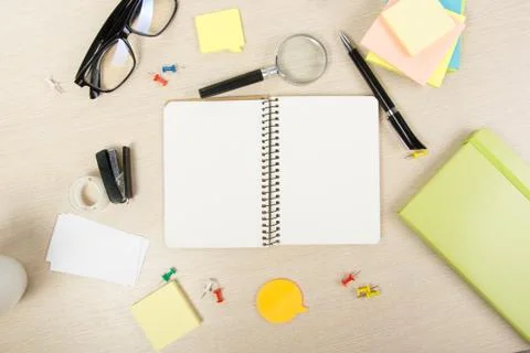 White blank open note book. Office table desk with set of colorful supplies, cup Stock Photos