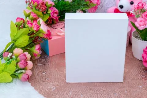 White blank rectangle box above a small tablecloth surrounded by valentine .. Stock Photos