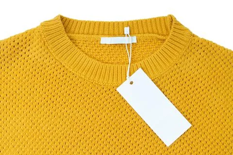 White blank rectangular clothing tag on yellow knitted sweater isolated on wh 스톡 사진
