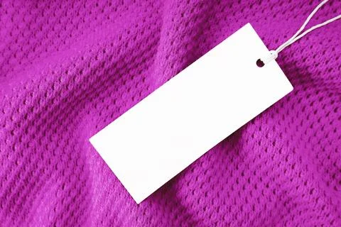 White blank rectangular clothing tag, label mockup template on purple knitted Stock Photos