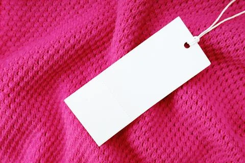 White blank rectangular clothing tag, label mockup template on pink knitted f 写真素材