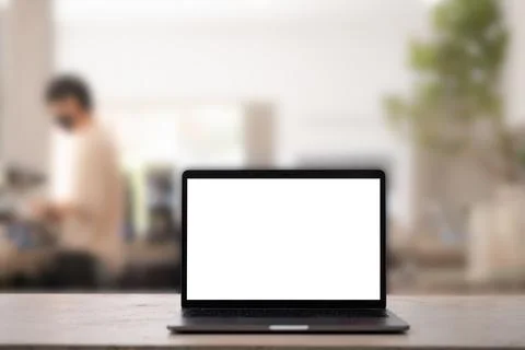 White blank screen tablet on modern working desk in coffee shop and barista on Foto stock