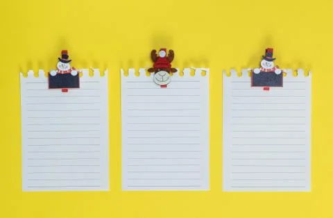 White blank sheet in a line torn out of notepad on a yellow background 스톡 사진