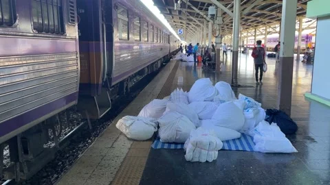 White blanket being thrown from train Hua Lamphong Station. Passengers walking Stock Footage 221680736