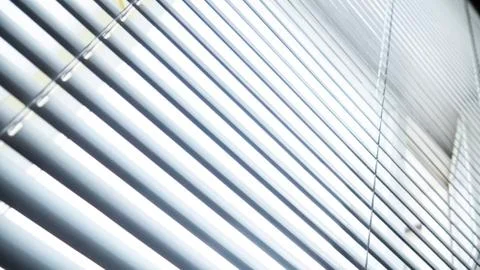 White blinds on the window. Sunlight from the window through the blinds Stock Photos