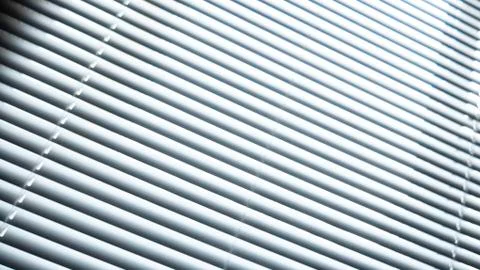 White blinds on the window. Sunlight from the window through the blinds 库存照片