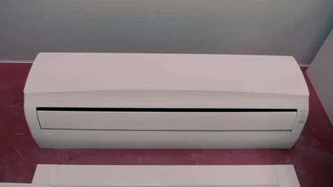 White block of air conditioner unit over the door on red wall next to ceiling Video stock 297767951