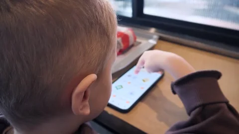 A white blond boy of 4-5 years old unlocks his phone by entering a code Stock Footage 306087121