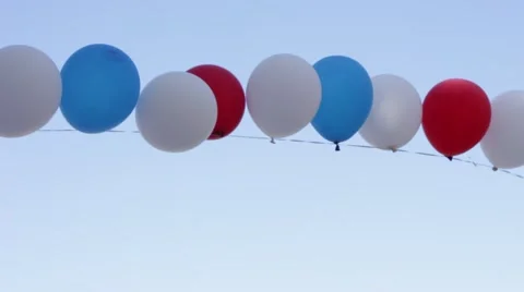 White, blue and red balloons trembling in the blue sky Vídeo Stock 68990988