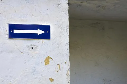 White on blue arrow pointer on old cracked walls Stock Photos