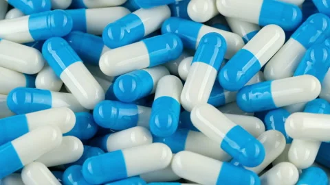White blue capsules pills falling down, zoom frame Stock Footage 253573794