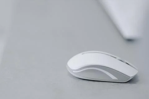White bluetooth mouse for computer on a gray table Stock Photos