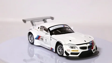 White BMW 24 GT3 scale model sports car is rotating isolated on white background Stock Footage 101728174