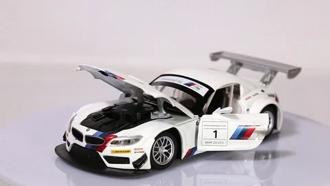 White BMW 24 GT3 scale model sports car with opened doors and hood Video stock 101728176