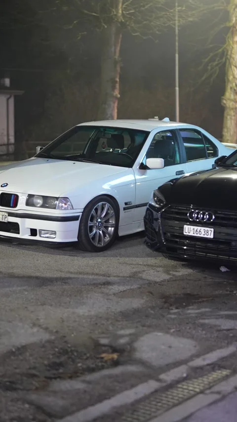 White bmw e36 and black audi a5 parked at night Stock Footage 333562678