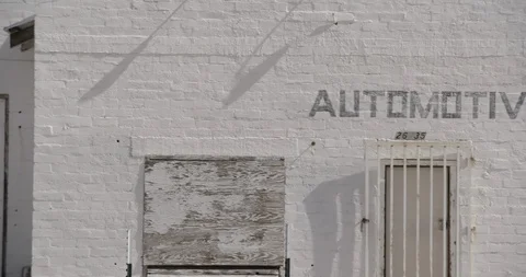 White Boarded Up Abandoned Gas Station in Desert - Close Up Pan Stock Footage 89942772