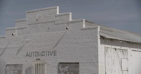 White Boarded Up Abandoned Gas Station in Desert - Three Quarter View - Pan Stock Footage 89942786