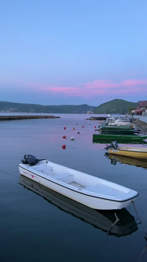 A white boat bobs on the surface of the river at the boat dock Stock Footage 279464967